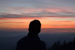 Man looking at colorful sunset 