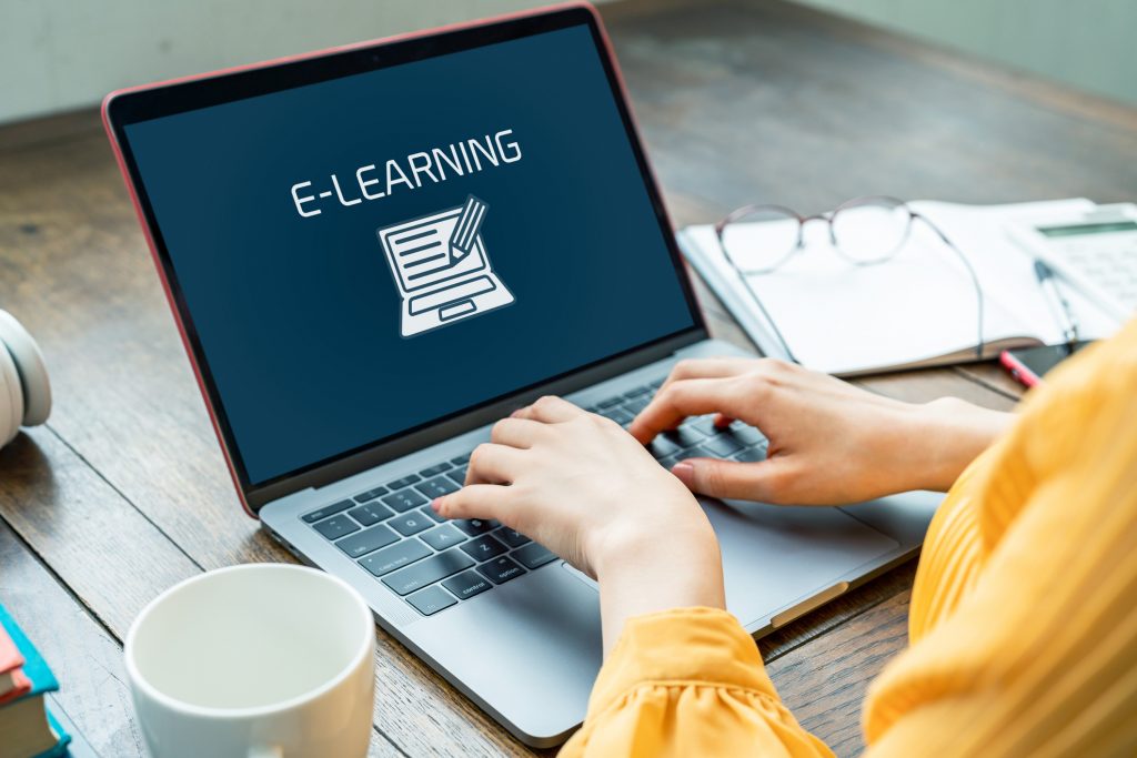 Woman typing on laptop with e-learning concept