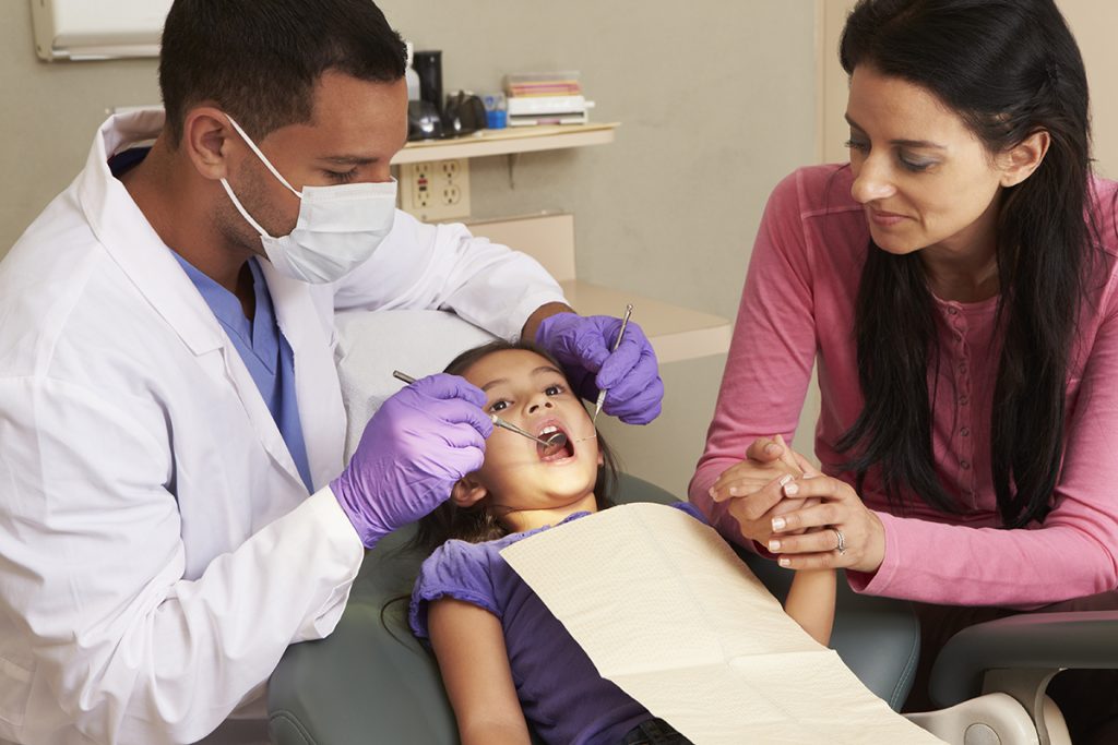 young girl receiving dental care accompanied by mother